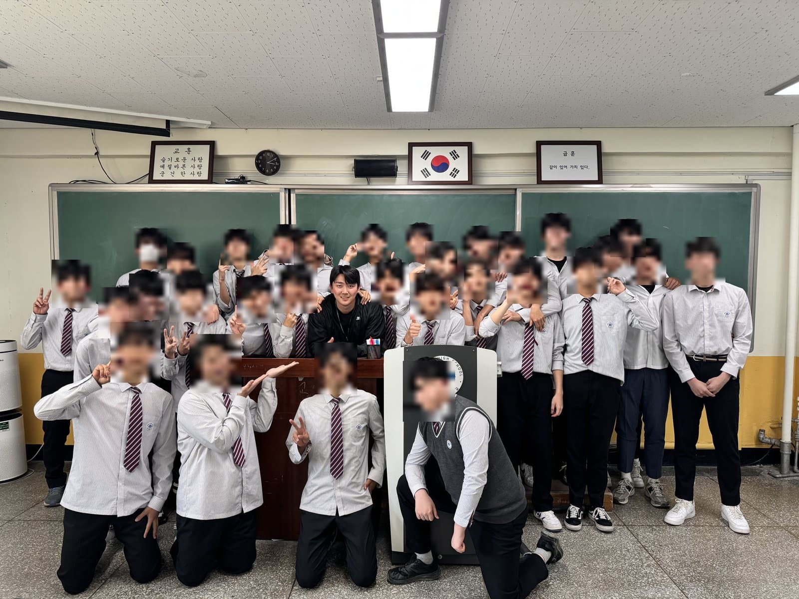 교실 칠판 앞에서 교생 실습 반 학생들과 함께 찍은 나영채 코치 (학생 얼굴은 가림)